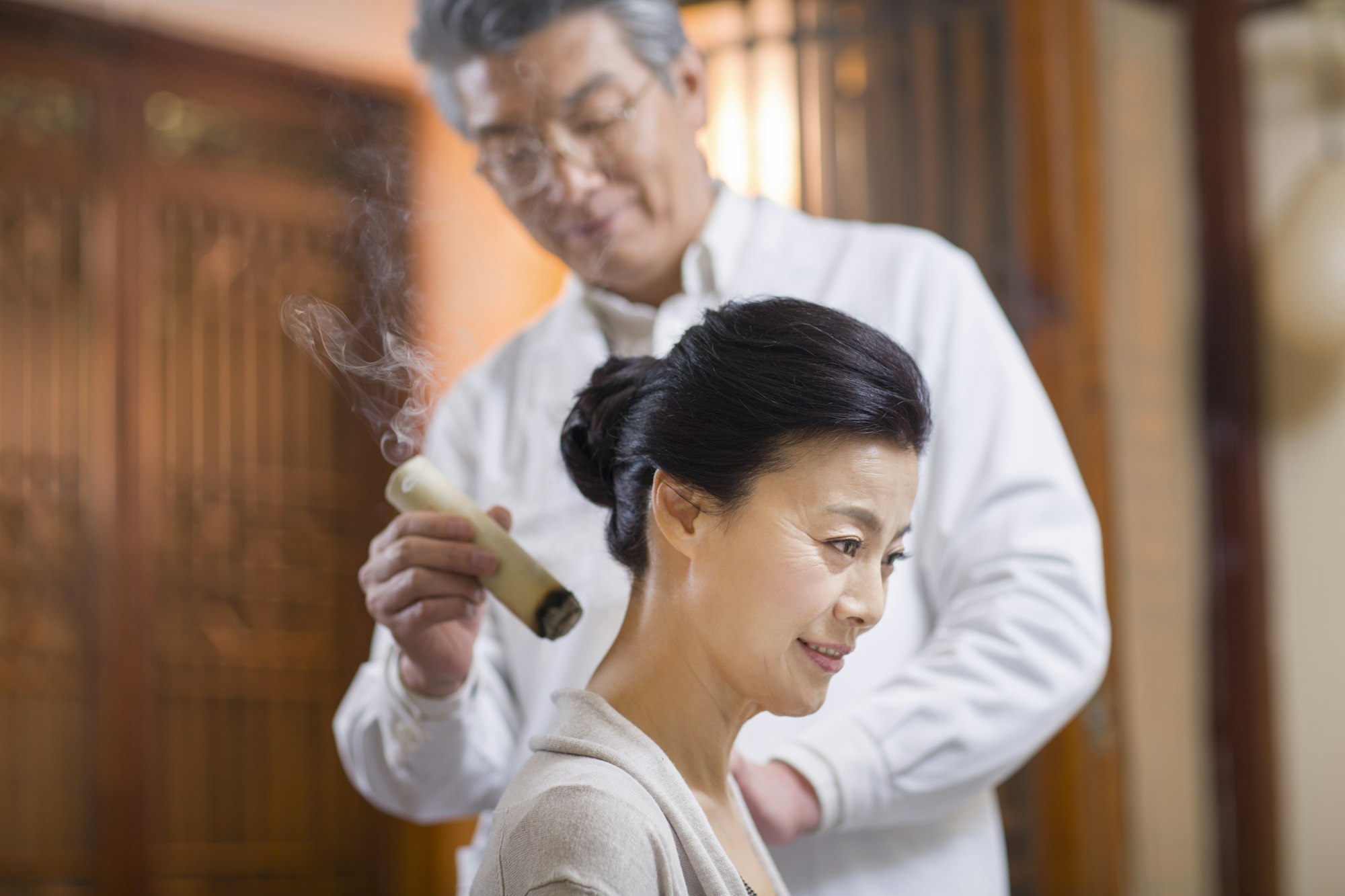 Senior Chinese doctor giving moxibustion